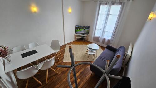 ein Wohnzimmer mit einem weißen Tisch und Stühlen in der Unterkunft Le Cozy Nest in Alfortville