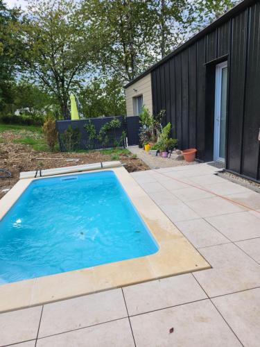 - une piscine dans un jardin avec une clôture noire dans l'établissement La petite maison d'Adèle, à Hargeville-sur-Chée