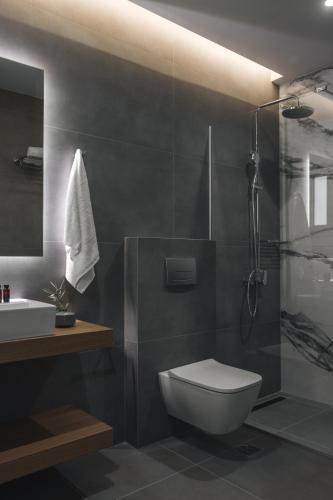 a bathroom with a toilet and a shower and a sink at Petroto Sea View Villas in Tsoukalades