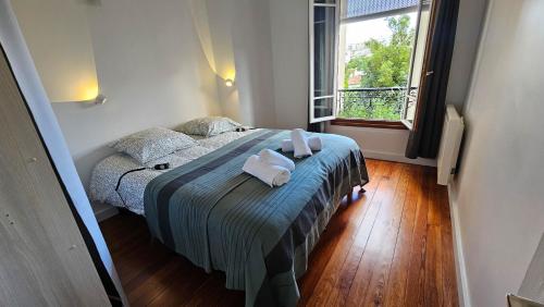 ein Schlafzimmer mit einem Bett mit zwei Handtüchern darauf in der Unterkunft Le Cozy Nest in Alfortville