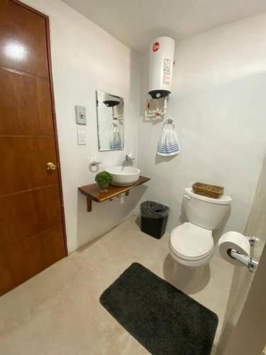 a bathroom with a toilet and a sink at La conchita de sisal 3 in Sisal
