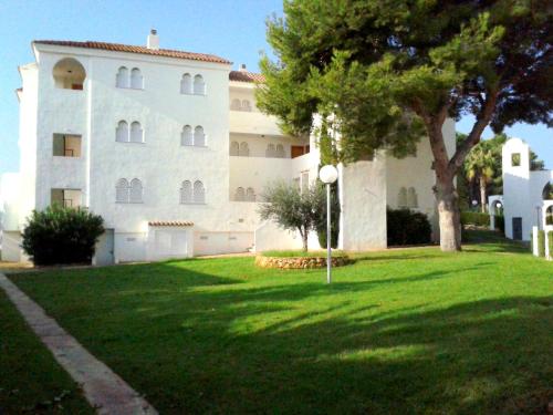 a large white building with a tree in front of it at APCOSTAS - Complejo Al Andalus in Alcossebre