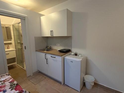 a small kitchen with white cabinets and a sink at SOS Apartments in Radovljica
