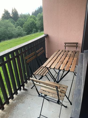 two benches sitting next to a wall on a balcony at Studio Cabine Chamrousse in Chamrousse