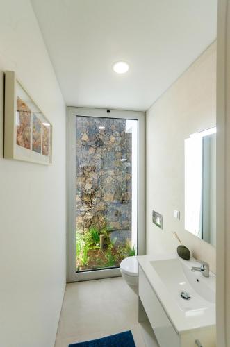 a bathroom with a toilet and a window at Casa Neptuno-Lagoa São Miguel in Lagoa