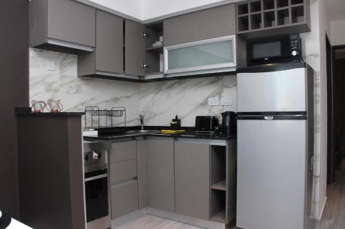 a kitchen with gray cabinets and a white refrigerator at In House BA - Le coq in Buenos Aires