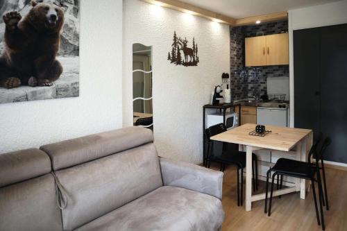 un salon avec un canapé et une table et une cuisine dans l'établissement Résidence Orr Des Neiges - LES ORRES 1650 coeur de station MAE-7501, aux Orres
