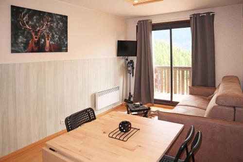 un salon avec une table et un canapé dans l'établissement Résidence Orr Des Neiges - LES ORRES 1650 coeur de station MAE-7501, aux Orres