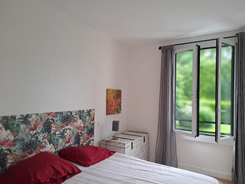 une chambre avec un lit avec des oreillers rouges et une fenêtre dans l'établissement A 800 m de la grande plage et du centre ville, à Biarritz