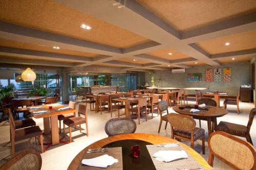 a restaurant with wooden tables and chairs and tablesktop at Carmel Charme Resort in Aquiraz