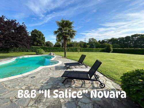 a patio with two chairs next to a swimming pool at IL SALICE in Novara