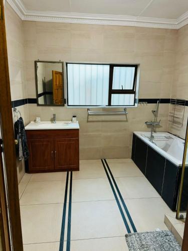 a bathroom with a tub and a sink at Amari Cottage in Boksburg