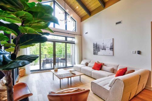 a living room with a couch and a table at Verbier C - Mont-Tremblant Pool Spa and Gym in Mont-Tremblant