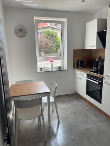 a small kitchen with a table and a window at Monteurwohnungen WalMel kostenloses Parken und W-LAN in Bütthard