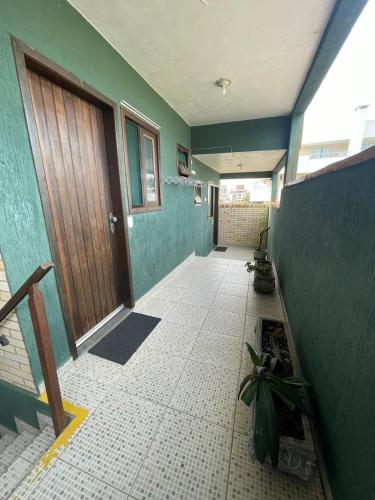 a hallway of a house with a door and a tile floor at Pousada Ramo de Acácia in Bombinhas