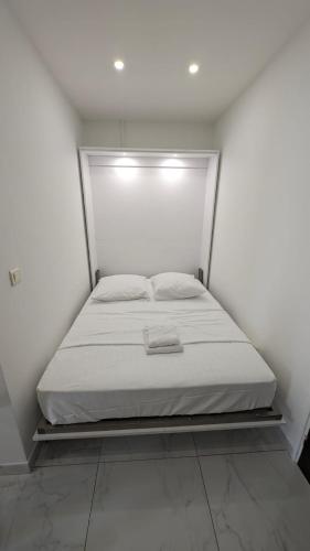 Ce lit se trouve dans un dortoir blanc doté d'un matelas blanc. dans l'établissement Studio neuf centre Cannes 500 m plage, à Cannes