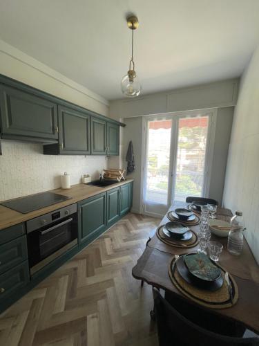 une cuisine avec des placards verts et une table en bois dans l'établissement Quartier hippodrome, à Cagnes-sur-Mer