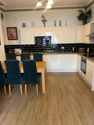 a kitchen with a wooden table and chairs at Marston town centre villa in Blackpool