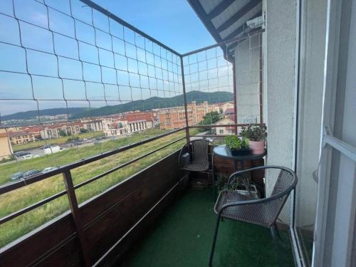 a balcony with two chairs and a table with a view at BRT Apartment in Floreşti