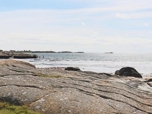 a beach with large rocks and the ocean at 4 star holiday home in VARBERG in Varberg