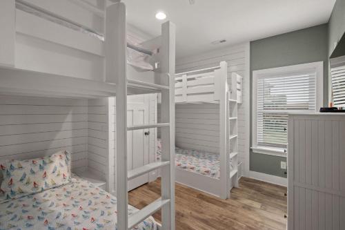- une chambre avec des lits superposés blancs dans l'établissement NH387C Oak Island Cottage, à Nags Head
