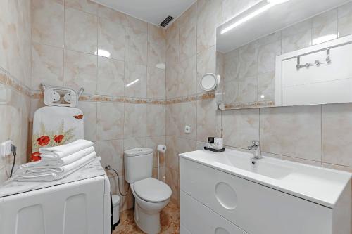 a white bathroom with a toilet and a sink at Tenerifeopenhome Costa Adeje comfort apartment 3 pools in Adeje
