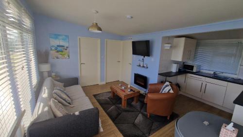 una sala de estar con un sofá y una mesa en 20 sea valley, en Bideford