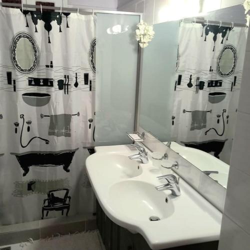 a bathroom with a sink and a shower curtain at Jimmy's garden in Korinthos