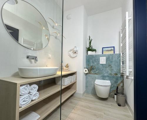 a bathroom with a sink and a mirror at Apartamenty Coastal Comfort Kołobrzeg in Kołobrzeg