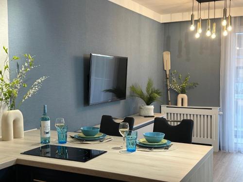 a dining room with a table with a television on the wall at Apartamenty Coastal Comfort Kołobrzeg in Kołobrzeg