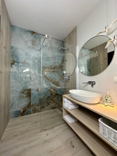 a bathroom with a sink and a mirror at Apartamenty Coastal Comfort Kołobrzeg in Kołobrzeg