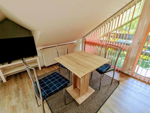 einen Tisch und 2 Stühle in einem Zimmer mit einem TV in der Unterkunft Ferienwohnung Am Fenn in Potsdam