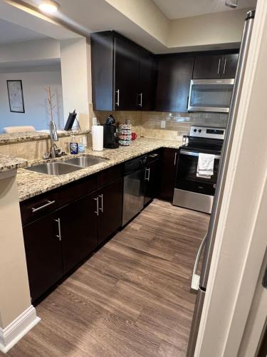 a kitchen with black cabinets and a sink at Spacious 2 Bedroom 2 Bathroom Apartment with Balcony in Uptown Charlotte! City Views & Free Parking! in Charlotte
