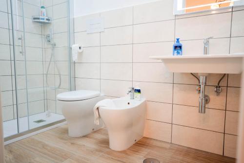 a bathroom with a toilet and a sink and a shower at Anna dei Sapori in Castelnuovo Cilento