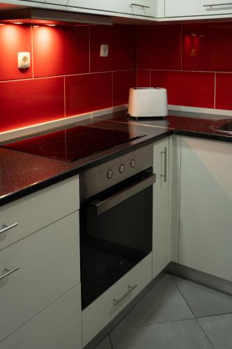 a kitchen with red walls and a stove top oven at Casa Valverde - Vale de Cambra in Vale de Cambra