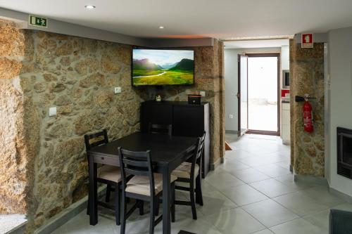 a dining room with a table and a tv on the wall at Casa Valverde - Vale de Cambra in Vale de Cambra