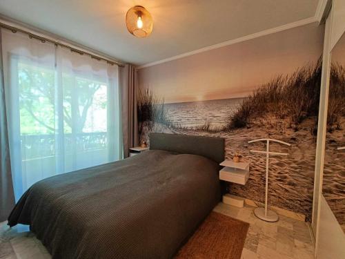 une chambre avec un lit avec un tableau sur le mur dans l'établissement La Résidence Fleuries - Plage, à Cannes