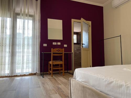 a bedroom with purple walls and a bed and a chair at Grandfather Superior Apartment in Berat