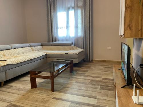 a living room with a couch and a coffee table at Grandfather Superior Apartment in Berat