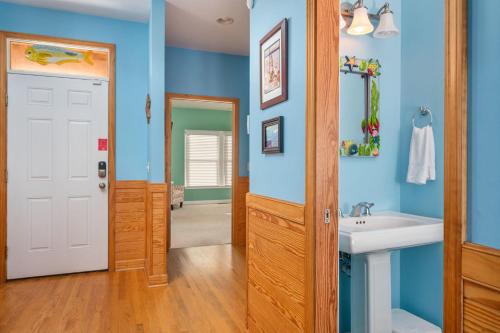 a bathroom with blue walls and a white sink at NH333 Capt Brad's in Nags Head
