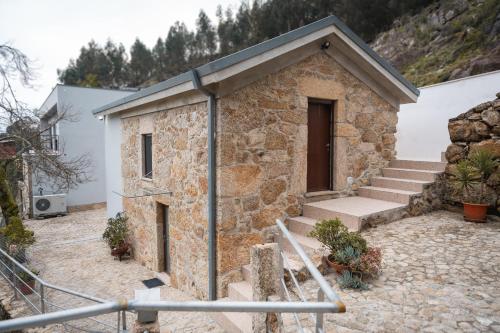 a small stone building with stairs and a door at Casa Valverde - Vale de Cambra in Vale de Cambra