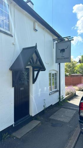 a white building with a black door and a sign at The Bulls Head - Clipston in Clipston