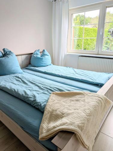 two beds with blue pillows on them in a bedroom at Ferienwohnung in Potsdam