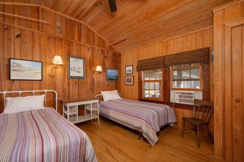 sypialnia z dwoma łóżkami w drewnianym pokoju w obiekcie NH324 Fred Wood Cottage w mieście Nags Head