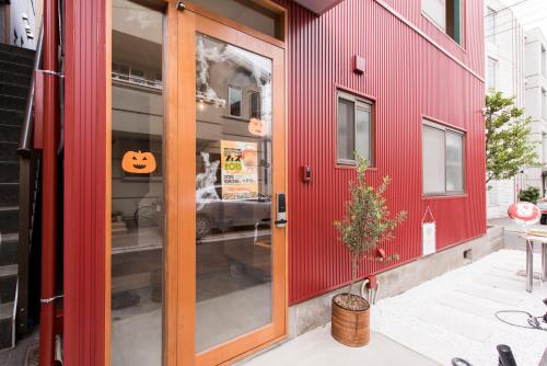 a red house with a pumpkin sign on the door at GrapeHouse Koenji in Tokyo