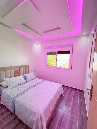 a bedroom with a bed with pink lights on the ceiling at Visit Chamal - Costa Midday in Oued Laou