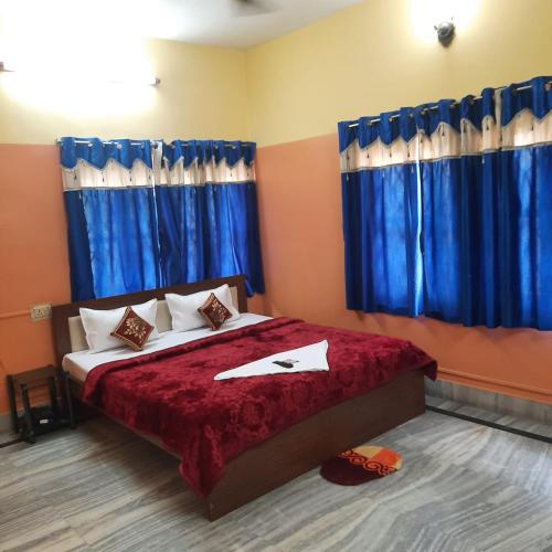 a bedroom with a large bed with blue curtains at Couple Friendly Rooms in kolkata