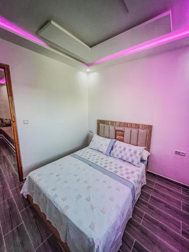 a bedroom with a bed with pink lights on it at Visit Chamal - Costa Midday in Oued Laou