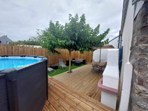 a backyard with a swimming pool and a wooden deck at Maison Bretonne avec piscine in Marzan