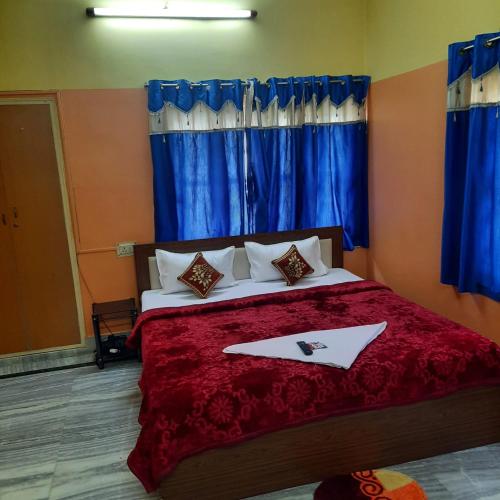 a bedroom with a large bed with blue curtains at Couple Friendly Rooms in kolkata